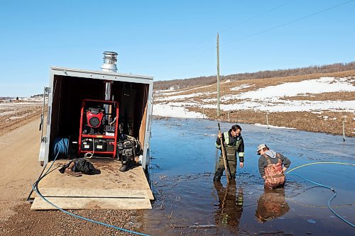 23032022
Jim Chessman and Fred Willman with the Rural Municipality of Whitehead work to clear ice from a culvert so melt water drains from next to a grid road west of Brandon on Wednesday.   (Tim Smith/The Brandon Sun)