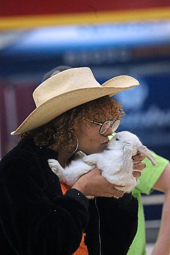 Volunteer Persia Wiebe shows a rabbit a little love at the Ricklynn Farms Petting Zoo during the opening day of the Royal Manitoba Winter Fair at the Keystone Centre, Monday. (Matt Goerzen/The Brandon Sun)