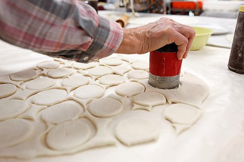 MIKE DEAL / WINNIPEG FREE PRESS
(from left) Cornelia Dombroski, Rosalie shupenia, and Jessie Sawicz cut the dough into discs with homemade stencils.
Holy Eucharist operates a year-round Perogy Hotline to raise funds for the church. Amid the crisis in Ukraine, the volunteers have started donating a portion of their proceeds to humanitarian efforts in the country.
see Eva Wasney story
220324 - Thursday, March 24, 2022.