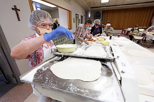 MIKE DEAL / WINNIPEG FREE PRESS
Anne Rybak at the rolling machine flattens the dough so that it can be cut out into round discs.
Holy Eucharist operates a year-round Perogy Hotline to raise funds for the church. Amid the crisis in Ukraine, the volunteers have started donating a portion of their proceeds to humanitarian efforts in the country.
see Eva Wasney story
220324 - Thursday, March 24, 2022.
