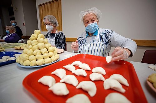 MIKE DEAL / WINNIPEG FREE PRESS
Sopia Kitasz places a pinched perogy onto her tray while a pyrdmid of balls of mashed potato wait to be made into perogies.
Holy Eucharist operates a year-round Perogy Hotline to raise funds for the church. Amid the crisis in Ukraine, the volunteers have started donating a portion of their proceeds to humanitarian efforts in the country.
see Eva Wasney story
220324 - Thursday, March 24, 2022.