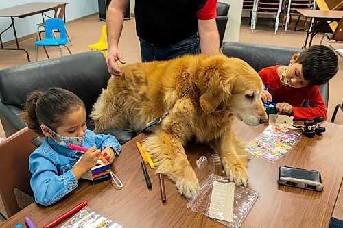 Therapy dog Jessie visits Aitana, 4, and Leonardo, 6, Arvizo during the Brandon and District Chapter Learning Disabilities Association of Manitoba (LDAM) Spring Reading Program for Children at the Brandon Public Library on Saturday, March 26. (Chelsea Kemp/The Brandon Sun)