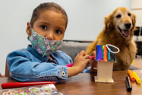 Therapy dog Jessie visits Aitana Arvizo, 4, during the Brandon and District Chapter Learning Disabilities Association of Manitoba (LDAM) Spring Reading Program for Children at the Brandon Public Library on Saturday, March 26. (Chelsea Kemp/The Brandon Sun)