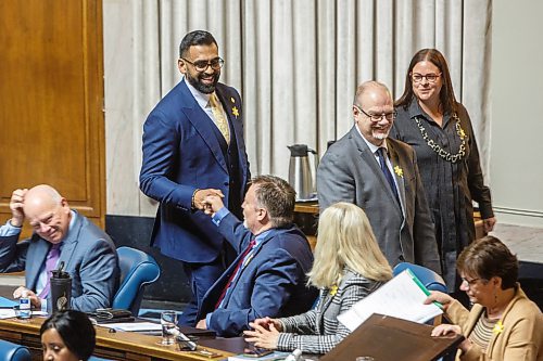 MIKE DEAL / WINNIPEG FREE PRESS
Obby Khan, MLA Fort Whyte, bumps fists with fellow in the assembly chamber for his first Question Period, Monday afternoon.
220404 - Monday, April 04, 2022.