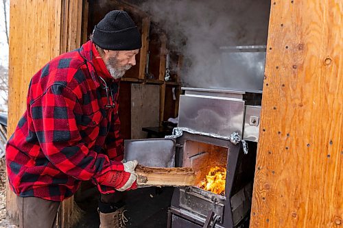 Dave Barnes adds fuel to the sap evaporator in his sugar shack at the Assiniboine Food Forest Saturday. (Chelsea Kemp/The Brandon Sun)