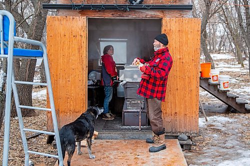 Maeve Cederstrom, left, and Dave Barnes man the sap evaporator Saturday at the Assiniboine Food Forest. (Chelsea Kemp/The Brandon Sun)