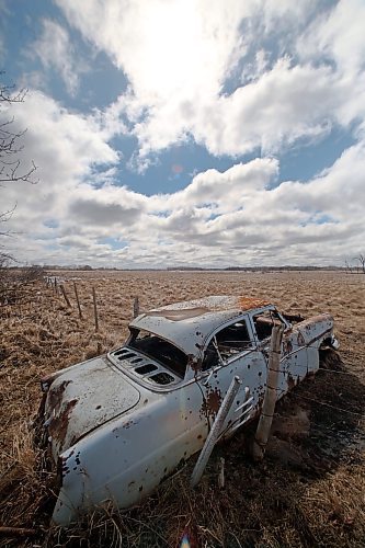 A rusted out Mercury Meteor serves as a fancy post for a barbed wire fence in a pasture west of Brandon, seen here on a cool spring day on Wednesday afternoon. (Matt Goerzen/The Brandon Sun)