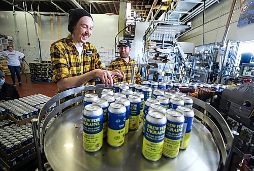 RUTH BONNEVILLE / WINNIPEG FREE PRESS

ENT - beer for Ukraine

Matthew Wolff (cap), Operations Manager at Torque Brewing, along with Kyle Maskiiw canning operator, are thrilled to start production of Ukraine Brew Friday.. Three thousand cans of the unique recipe will be produced with proceeds going to the Ukraine Crisis.  

Subject: Eight local craft breweries in Winnipeg are collaborating on a beer, with all proceeds going to a humanitarian relief fund in Ukraine. The beer recipe is from Pravda Brewing, a Ukrainian brewery based in Lviv.

The breweries collaborating are: Torque Brewing, Trans Canada Brewing, Nonsuch Brewing, Barn Hammer Brewing, One Great City Brewing, Devil May Care Brewing, Lake of the Woods Brewing, and Stone Angel Brewing.

Eva Wasney



April 8th,  2022
