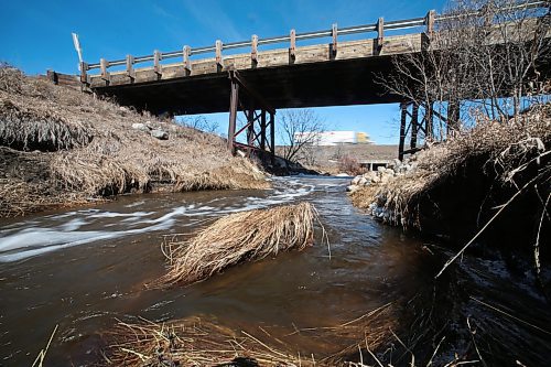 Spring meltwater flows swiftly through a creek and under a municipal bridge south of the Trans-Canada Highway near CFB Shilo on Friday afternoon. (Matt Goerzen/The Brandon Sun)