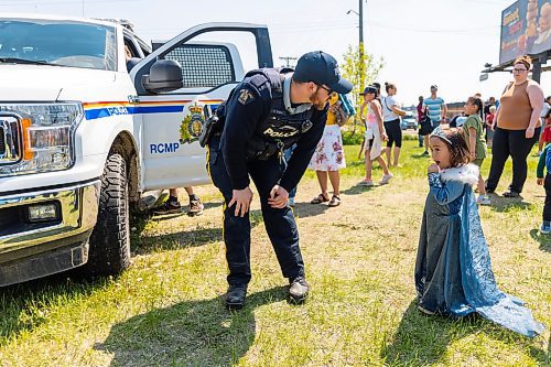 Officer Kyle Slater, left, greets Adaline Kuijpers, 3, dressed as Disney Princess Elsa during Touch-a-Truck at the Keystone Centre grounds Saturday. (Chelsea Kemp/The Brandon Sun)