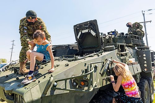 Stefan Eberts, 7, climbs out of a Light Armoured Vehicle with help from Pte. Felix Louselle during Touch-a-Truck at the Keystone Centre grounds Saturday. (Chelsea Kemp/The Brandon Sun)