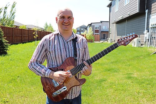 Emmanuel Bach poses for a photo with his guitar outside his Brandon home on Sunday afternoon. The Brazilian musician just moved to the Wheat City with his family back in November and has already embedded himself in the local music scene by forming a new band. (Kyle Darbyson/The Brandon Sun)