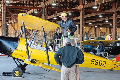 Commonwealth Air Training Plan Museum volunteer Colin Craddock cleans the wing of an old Canadian Tiger Moth on Sunday morning as fellow volunteer Jeff Bell looks on.(Kyle Darbyson/The Brandon Sun)