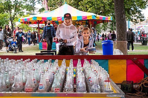 Daniel Crump / Winnipeg Free Press. Christie Marsh (left) and Jordyn Denomme play a ring toss game at Manyfest in Winnipeg, Saturday afternoon. September 10, 2022.