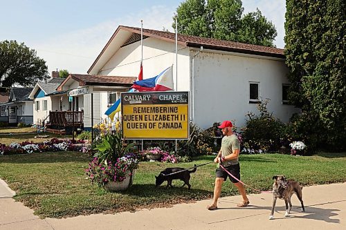 12092022
Devin Drury walks his dogs past Calvary Chapel in Neepawa and a sign outside the church in commemoration of Queen Elizabeth II on a hot Monday afternoon.  (Tim Smith/The Brandon Sun)
