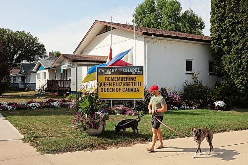 12092022
Devin Drury walks his dogs past Calvary Chapel in Neepawa and a sign outside the church in commemoration of Queen Elizabeth II on a hot Monday afternoon.  (Tim Smith/The Brandon Sun)
