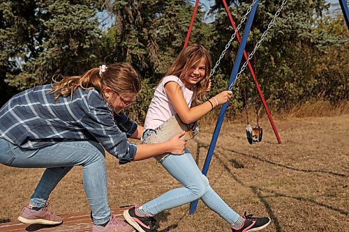 12092022
Hannah Cousley pulls back Skyler Smith to give her a big push on a swing as students at Edrans Christian School in the small community of Edrans, north of Sidney, Manitoba, play outside during lunch recess on a hot Monday. The private school currently has eight students between grades K-9 enrolled.  (Tim Smith/The Brandon Sun)
