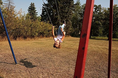 12092022
Skyler Smith looks back at friends while swinging at Edrans Christian School in the small community of Edrans, north of Sidney, Manitoba, during lunch recess on a hot Monday. The private school currently has eight students between grades K-9 enrolled.  (Tim Smith/The Brandon Sun)
