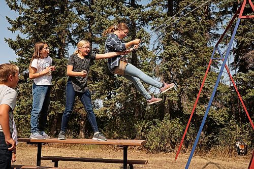 12092022
Hannah Cousley swings as Hunter Smith, Makenzie Cousley and Brooke Smith watch at Edrans Christian School in the small community of Edrans, north of Sidney, Manitoba, during lunch recess on a hot Monday. The private school currently has eight students between grades K-9 enrolled.  (Tim Smith/The Brandon Sun)
