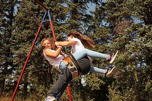 12092022
Skyler Smith and Makenzie Cousley swing at Edrans Christian School in the small community of Edrans, north of Sidney, Manitoba, during lunch recess on a hot Monday. The private school currently has eight students between grades K-9 enrolled.  (Tim Smith/The Brandon Sun)
