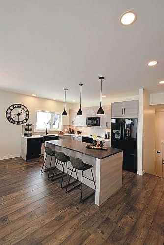 Todd Lewys / Winnipeg Free Press
An eight-foot island with grey/taupe thermofoil base and dark taupe matte quartz countertops serves as the centrepoint  of the striking, modern farmhouse kitchen.