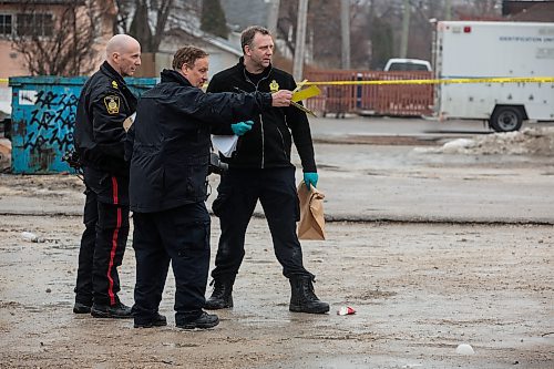 MIKE DEAL / WINNIPEG FREE PRESS Members of the Winnipeg Police Indent Unit collect evidence from an early morning shooting behind some businesses close to Henderson Hwy and Hazel Dell Avenue. A knife and a bullet casing were photographed and collected as well as pieces from at least one car. Two vehicles were towed away from the scene. Police tape surrounds a house that faces onto Hazel Dell right at the end of the back ally. 160313 - Sunday, March 13, 2016