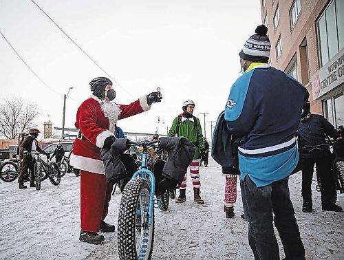 JESSICA LEE / WINNIPEG FREE PRESS



Kerry LeBlanc (in Santa suit) and two dozen volunteers bike near downtown on December 17, 2021, as part of &#x2018;Cycling with Santa&#x2019;. The group travels through the community, handing out candy canes, toques and warm gear that they bring themselves. This is their 10th year cycling together and spreading cheer.