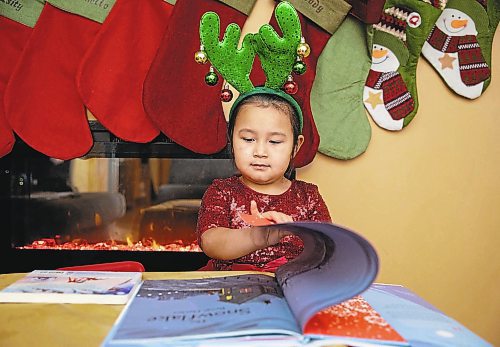 JESSICA LEE / WINNIPEG FREE PRESS

Quinn, 4, is photographed in her home reading Christmas books on December 7, 2021.