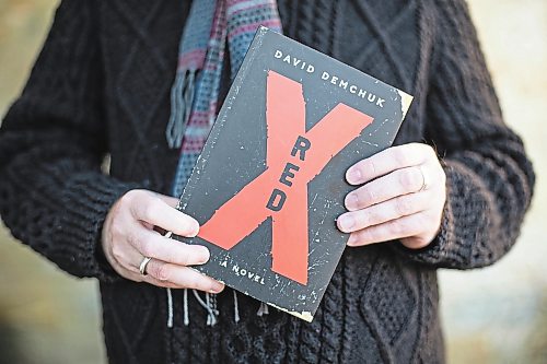 Daniel Crump / Winnipeg Free Press. David Demchuk holds a copy of his book Red X, which is a gay horror novel about an evil entity stalking the gay community in Toronto over a period of centuries. December 4, 2021.