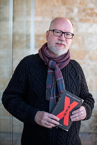 Daniel Crump / Winnipeg Free Press. David Demchuk poses with a copy of his book Red X, which is a gay horror novel about an evil entity stalking the gay community in Toronto over a period of centuries. December 4, 2021.