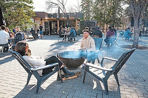 Daniel Crump / Winnipeg Free Press. Luciana Lazo and Carl Alfaro enjoy a warm spring afternoon beside a fire pit at Cargo Bar at Assiniboine Park. April 24, 2021.