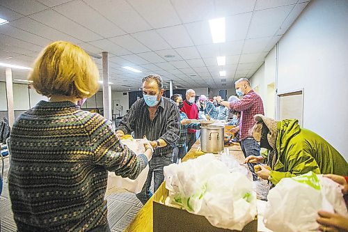 MIKAELA MACKENZIE / WINNIPEG FREE PRESS

Joe Conci (centre) and Annie Hollander (left) pack up a hot Christmas meal for folks in need to take home at the Mission Baptist Church in Winnipeg on Saturday, Dec. 25, 2021.  For Malak story.
Winnipeg Free Press 2021.