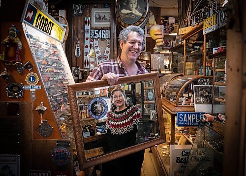 JESSICA LEE / WINNIPEG FREE PRESS



Mike Huen of Mike&#x2019;s General Store is photographed on December 30th, 2021 holding the mirror which wife Barb (pictured in mirror) initially sold to him, years ago. Because of the mirror, they ended up meeting and eventually marrying.



Reporter: Gabby