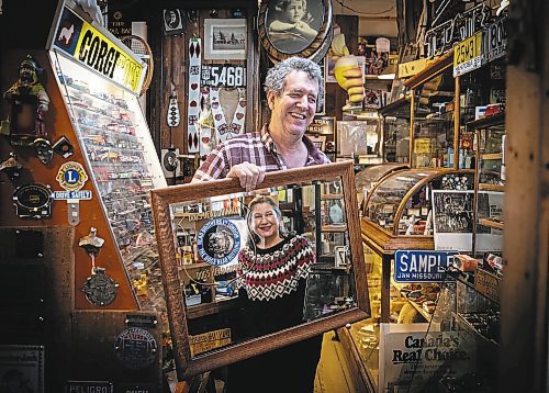 JESSICA LEE / WINNIPEG FREE PRESS



Mike Huen of Mike&#x2019;s General Store is photographed on December 30th, 2021 holding the mirror which wife Barb (pictured in mirror) initially sold to him, years ago. Because of the mirror, they ended up meeting and eventually marrying.



Reporter: Gabby