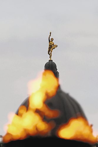 SHANNON VANRAES/WINNIPEG FREE PRESS

The Centennial Flame on Memorial Boulevard has been lit to mark the beginning of Remembrance Day activities throughout Manitoba and appeared to devour the top of the Legislative Building on October 29, 2021.