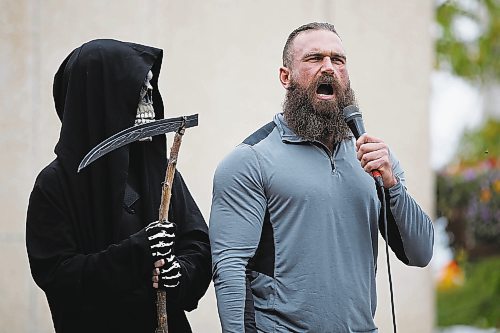 JOHN WOODS / WINNIPEG FREE PRESS
A person dressed as the Grim Reaper looks on as organizer Shaun Zimmer speaks to about 150 anti-maskers/vaxxers gathered at the MB Legislature and walked to the City Hall in protest against COVID-19 vaccinations and masks in Winnipeg Monday, September 13, 2021. 

Reporter: Silva