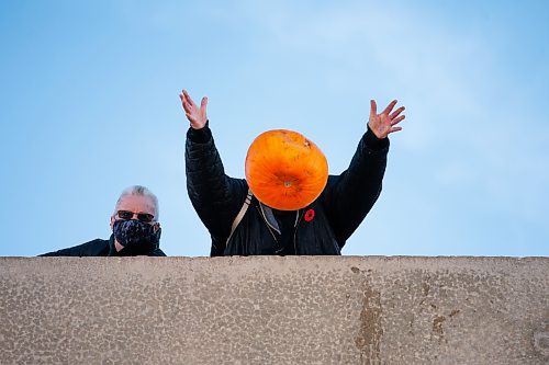 Daniel Crump / Winnipeg Free Press. A person hurls their pumpkin from the second story of the Polo Park parkade Saturday morning as part of the Compost Manitoba Pumpkin Drop. The pumpkins are later composted or donated to local farm as feed for animals. November 6, 2021.