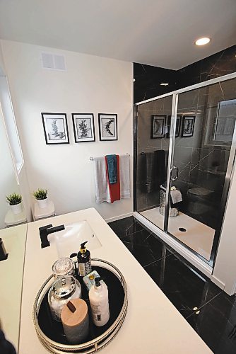 Todd Lewys / Winnipeg Free Press
Black marble on the floor and in the shower contrasts beautifully with an off-white quartz countertop on the flat panel oak vanity to offer the stunning ensuite some contemporary contrast.