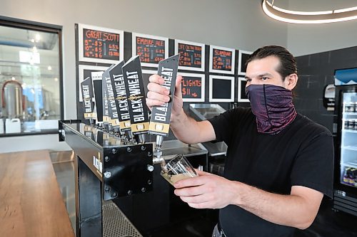 Rob Zichrul, head bartender for Black Wheat Brewing, pours a pint during the opening day of the taproom in 2021.  (File/The Brandon Sun)