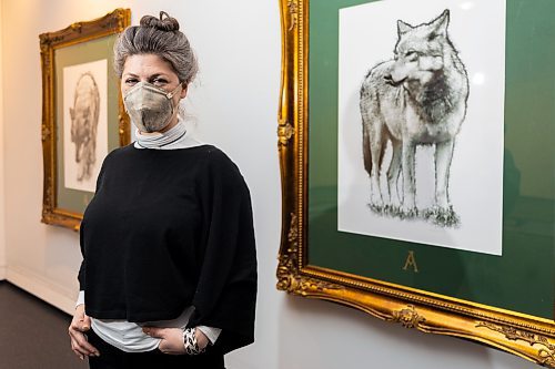 Curator Lucie Lederhendler stands next to artwork by Mary Anne Barkhouse, whose exhibit "opimihaw" is installed at the Art Gallery of Southwestern Manitoba. (Chelsea Kemp/The Brandon Sun)