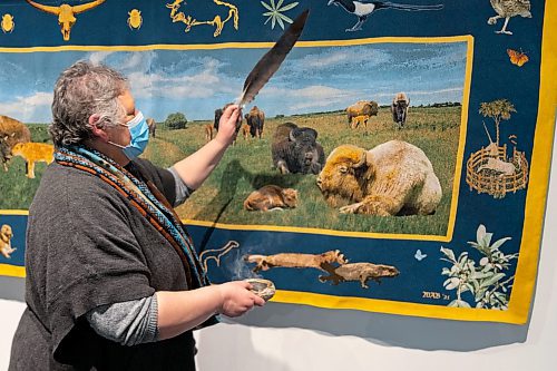 Sweet Medicine Singer Debbie Huntinghawk provides a smudging at the Art Gallery of Southwest Manitoba Thursday during the opening of artist Mary Anne Barkhouse&#x2019;s exhibit opimihaw. (Chelsea Kemp/The Brandon Sun)