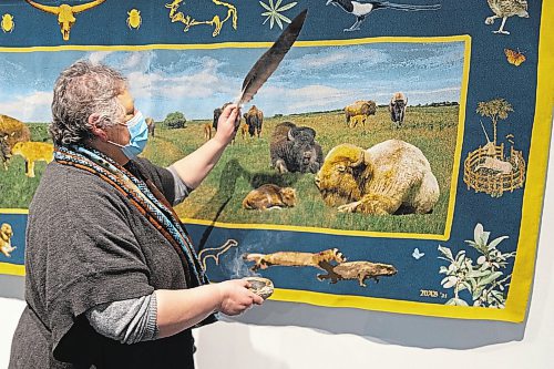 Sweet Medicine Singer Debbie Huntinghawk provides a smudging at the Art Gallery of Southwest Manitoba Thursday during the opening of artist Mary Anne Barkhouse’s exhibit opimihaw. (Chelsea Kemp/The Brandon Sun)