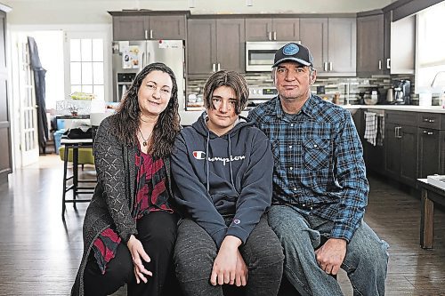 28012022
Rainey Delaurier, 13, with his parents Cher Andruski and Tom Delaurier, at their home in Brandon on Friday. Delaurier lives with Ollier disease, a rare bone disease, and will be travelling to Montreal for surgery this week.  (Tim Smith/The Brandon Sun)
***please cross reference with Karen's story*** 