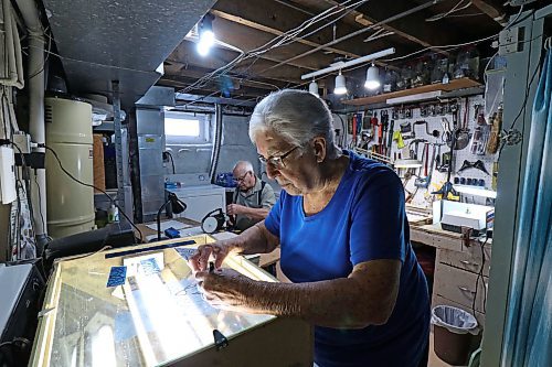Vivian Bazin traces a new glass pattern while her husband, Raymond, prepares a new piece of glass to be soldered. (Joseph Bernacki/The Brandon Sun)