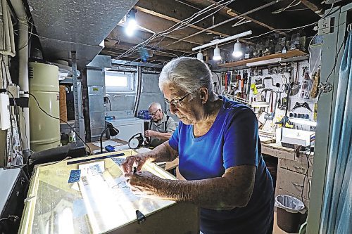 Vivian Bazin traces a new glass pattern while her husband Raymond prepares a new piece of glass to be soldered. (Joseph Bernacki/The Brandon Sun)