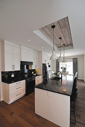Todd Lewys / Winnipeg Free Press
The kitchen is anchored by a 10-foot island with gorgeous black granite countertops and a ceiling featuring a barn wood accent.
