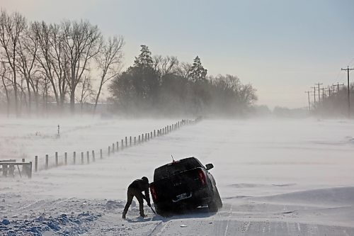 A driver tries to dig a pickup truck out of a snow drift after getting stuck while trying to rescue another stuck vehicle on a grid road just outside Brandon during blizzard conditions on Tuesday. (Tim Smith/The Brandon Sun)