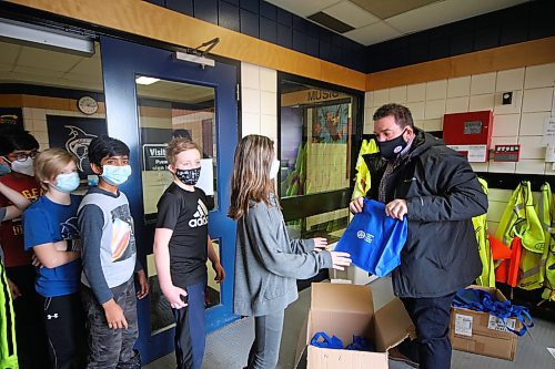 Brandon CAA Manitoba store manager Chris Heide hands out swag bags to students at Waverly Park School Tuesday afternoon. (Drew May/The Brandon Sun)