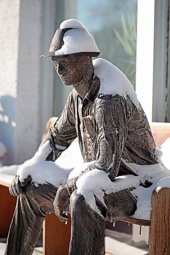 Snow clings to a statue of a man in front of Inspire Art Studio in Minnedosa on a cold Wednesday. (Tim Smith/The Brandon Sun)