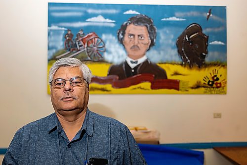 John Fleury, Manitoba Métis Federation minister of Indigenous skills and employment training strategy, poses for a photo in front of a portrait of Louis Riel. (Chelsea Kemp/The Brandon Sun)